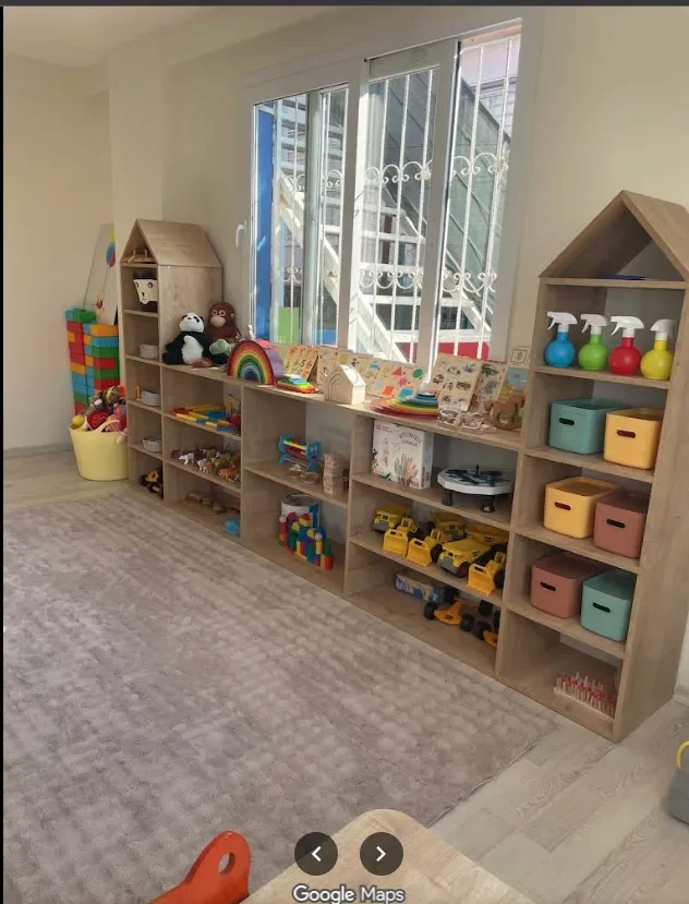 Geniş sınıfımız — ahşap montessori dolaplar ve düzenli oyuncak köşesi